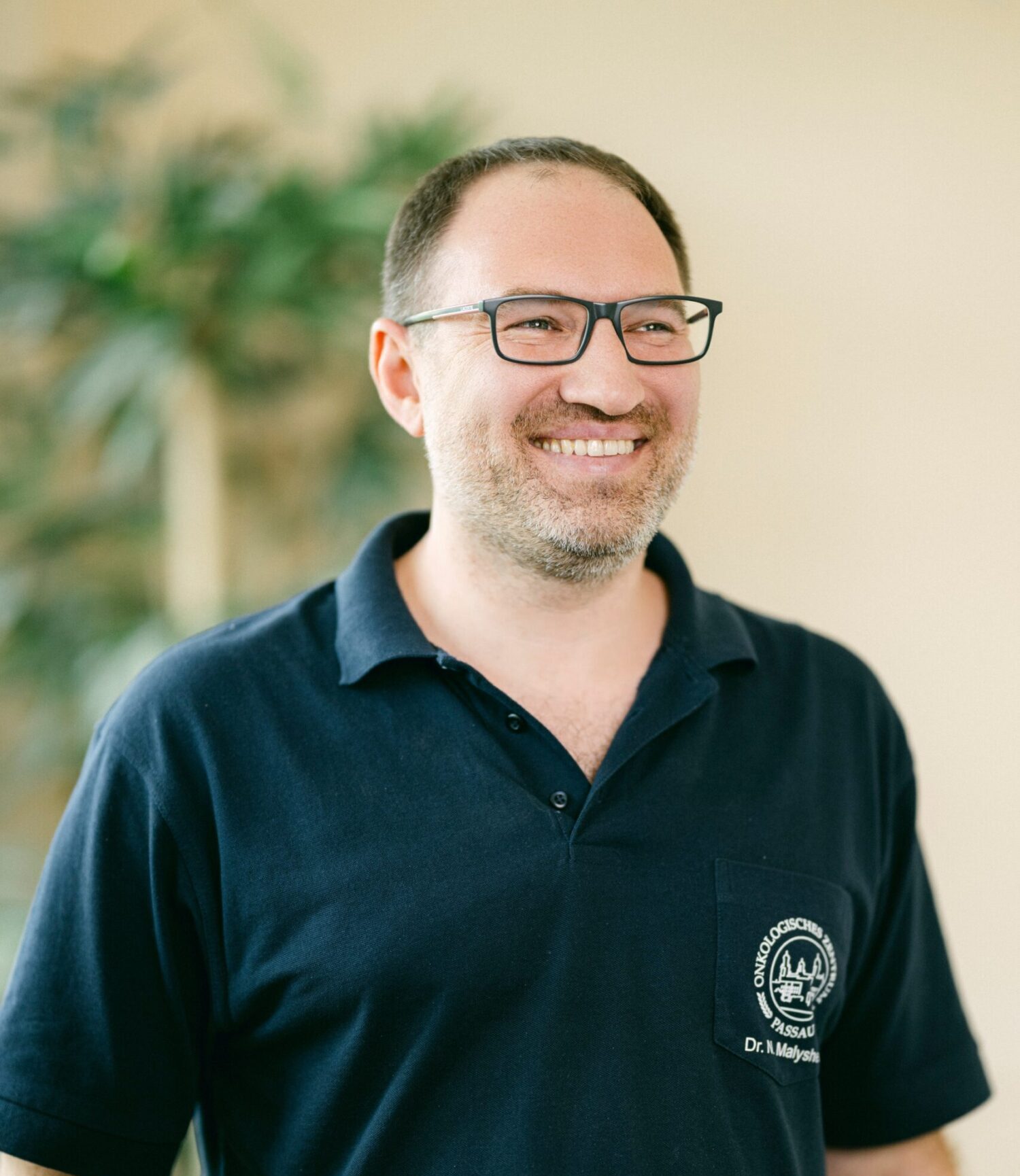 Dr. Malyshev ist zu sehen, der in die Kamera lächelt.