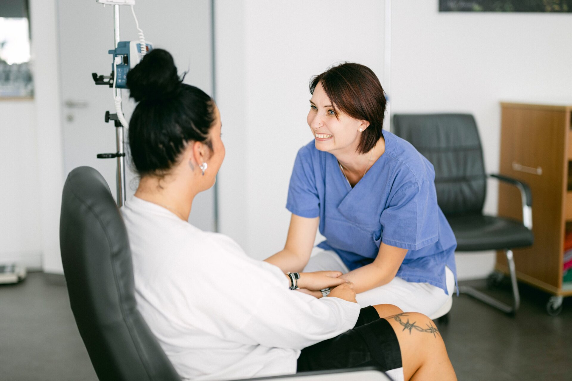 Eine MFA kümmert sich um eine Patientin, die in einem Behandlungsstuhl sitzt.