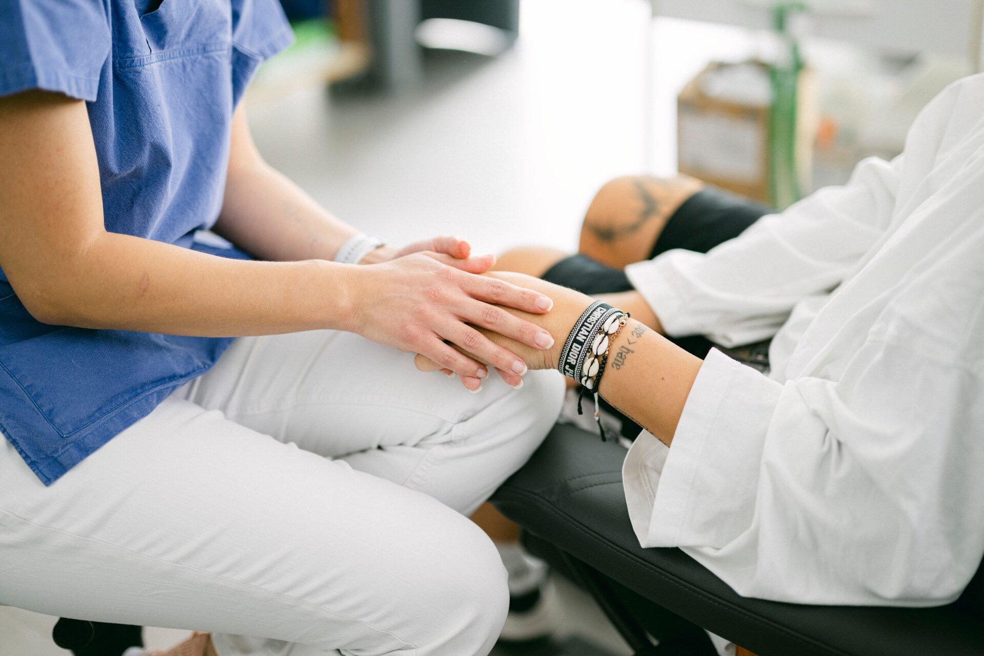 Eine MFA hält die Hand einer Patientin.